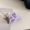 Detail of light purple glossy claw clip with twisted design on tulip card background - Twist Knot Style / Creamy Purple