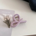 Detail view of a lavender twisted hair claw clip with a glossy finish on a white surface - Twist Knot Style / Taro Pink