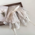 Dettaglio di un elegante elastico in tessuto plissettato blu ghiaccio con perle e fiocco - Fermaglio con Nastro Bianco