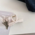 Detail of a creamy butterfly hair claw clip with golden spring on a white desktop - Small Bow Style / Cream White
