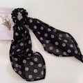 Dettaglio di un elastico in chiffon nero con motivi a onde bianche e lunghi nastri eleganti - Scrunchie con Nastro / Nero