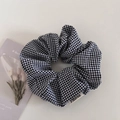 Dettaglio dell'elastico per capelli a quadretti bianchi e neri con etichetta in tessuto FMDrea - Quadri Nero