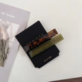 Close-up of tortoiseshell and matte green acetate hair clips on a minimalist card - Green Brown