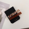 Close-up of tortoise shell and marble acetate hair clips on a black brand card - Light Coffee White