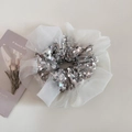 Detail of white organza scrunchie with sparkling silver sequins on a plain background - Beige