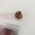 Detail of a mini acetate hair claw with a brown marble pattern and gold France logo - 10# Coffee Green