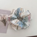 Dettaglio di scrunchie floreale con motivi a quadri blu e pois rosa su bianco - Stile Giuntato Vita Sottile / Blu