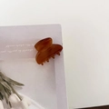 Close-up of a mini amber acetate hair claw clip with vintage glossy finish on paper - Caramel Coffee