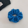 Macro view of blue cotton scrunchie texture with white woven label on neutral background - 1# Blue