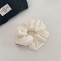 Close-up of ivory cotton scrunchie with natural pleated texture and FMdrea logo tag - Off-white