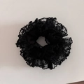 Detailed view of black polka dot lace scrunchie with elegant ruffled fabric edges - Black