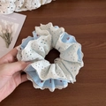 Hellblaues Karo-Haargummi mit Kirschdruck und weißem Spitzenbesatz in der Hand - Spitzen-Patchwork-Stil / Blau Spitzenbesatz-Stil