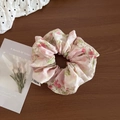 Dettaglio dell'elastico a fiori su tavolo di legno con cartolina di tulipani ed etichetta - Rosa