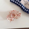 Macro view of high-quality pink acetate hair claw clip with floral marble texture - White Pink Orange