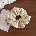 Dettaglio di elastico floreale con motivi rosa e verdi su sfondo in legno marrone - Verde