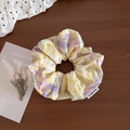 Dettaglio dell'elastico per capelli floreale vintage con etichetta su sfondo rustico - Giallo