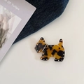 Vue détaillée d'une pince à cheveux chien en acétate avec strass sur du denim - Écaille de Tortue Foncée