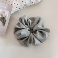 Detail of a large grey satin scrunchie with soft silk texture and elegant folds - Green