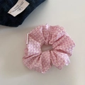 Close-up of pink checkered scrunchie with polka dots and soft pleated fabric texture - Pink