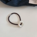 Dettaglio di un elastico per capelli marrone con anello in acrilico effetto marmo - Bianco Marmorizzato