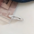 Detailed view of hollow acetate hair clip with elegant white marble pattern and metal clasp - Pearlescent White