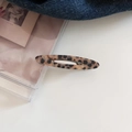 Detailed view of leopard print acetate hair clip with hollow oval design and metal spring - Leopard Print