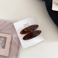Detalle de pinzas ovaladas de carey con el texto Barrette la France en tarjeta - Azul Marrón
