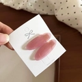 Close-up of pink translucent oval hair clips with gold handmade logo on white card - Pink