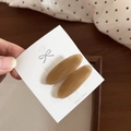 Detailed view of oval amber acetate hair clips on a white presentation card - 6#Light Coffee