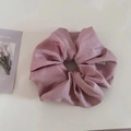 Detalle del coletero de satén violeta suave con textura plisada y brillo de seda - Rosa