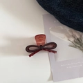 Détail de la pince à cheveux nœud en acétate marron rouge sur denim et carte d'art - Café Foncé
