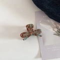 Détail d'une pince à cheveux en acétate marbré marron et bleu clair en forme de nœud - Café Vert