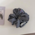 Detalle de coletero de cuadros con parche de perro lindo y etiqueta tejida decorativa - Coletero Perro Lunares Blanco y Negro