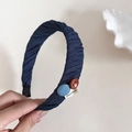 Details der Textur des marineblauen Stoffhaarbands mit Holzknöpfen und Handarbeit-Etikett - Dunkelblaues Stirnband