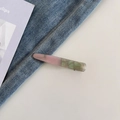 Dettaglio del fermaglio per capelli in acetato con trama marmorizzata rosa e verde e logo oro - Rosa e Verde Marmorizzato