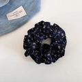 Primer plano detallado de coletero floral azul marino con perla y textura de tela suave - Azul Marino Floral