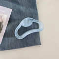 Detalle de una pinza para el cabello azul claro con textura de mármol sobre tela vaquera - Azul Degradado