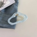Detalle de la pinza para el pelo azul claro con resorte dorado sobre tela vaquera - Azul Degradado