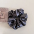 Close-up of a large dark grey satin scrunchie with silky texture and elegant folds - 1# Gray
