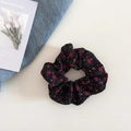 Detalle de un coletero vintage negro con estampado floral rojo sobre un fondo blanco - Negro