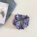 Vista de plano detalle de un coletero azul con flores rojas sobre un fondo blanco puro - Azul