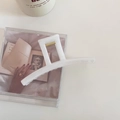 Détail d'une pince à cheveux rectangulaire blanc crème avec ressort doré sur fond esthétique - Blanc