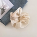 Detailopname van crème organza scrunchie met parelglans en fijne textuur plooien - Beige