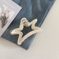 Vista de detalle de la pinza para el pelo en forma de estrella con textura de mármol y muelle - Albaricoque