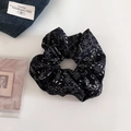 Gedetailleerde close-up van een zwarte paisley scrunchie met vintage patronen op wit decor - Zwart Paisley