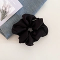 Detail van een grote zwarte chiffon scrunchie met fijne textuurplooien en een klein label - 2# Donkere Koffie