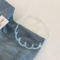 Dettaglio del cerchietto ondulato azzurro con denti antiscivolo su sfondo in denim blu - 3# Blu Trasparente