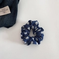 Detailed close-up of denim scrunchie with white floral embroidery on textured surface - Small Hoop / Dark Blue Floral