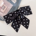 Macro detail of the retro black and white polka dot satin fabric on the hair claw clip - Black Polka Dot Style