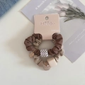 Detail view of coffee and beige satin hair scrunchies with gold tags on pink card - Two-Piece Set / Coffee Colors
